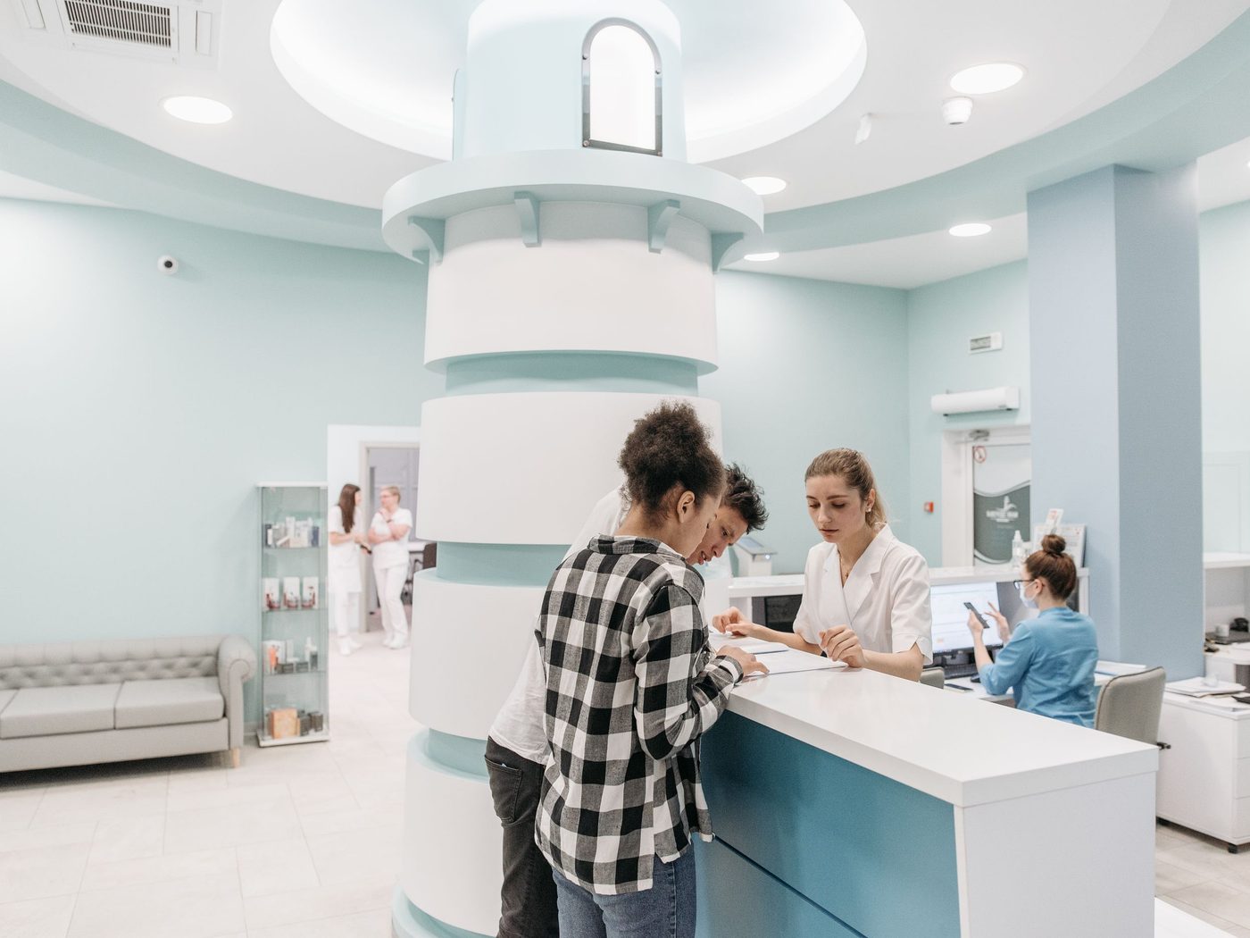 Patients being welcomed at a bright clinic reception desk