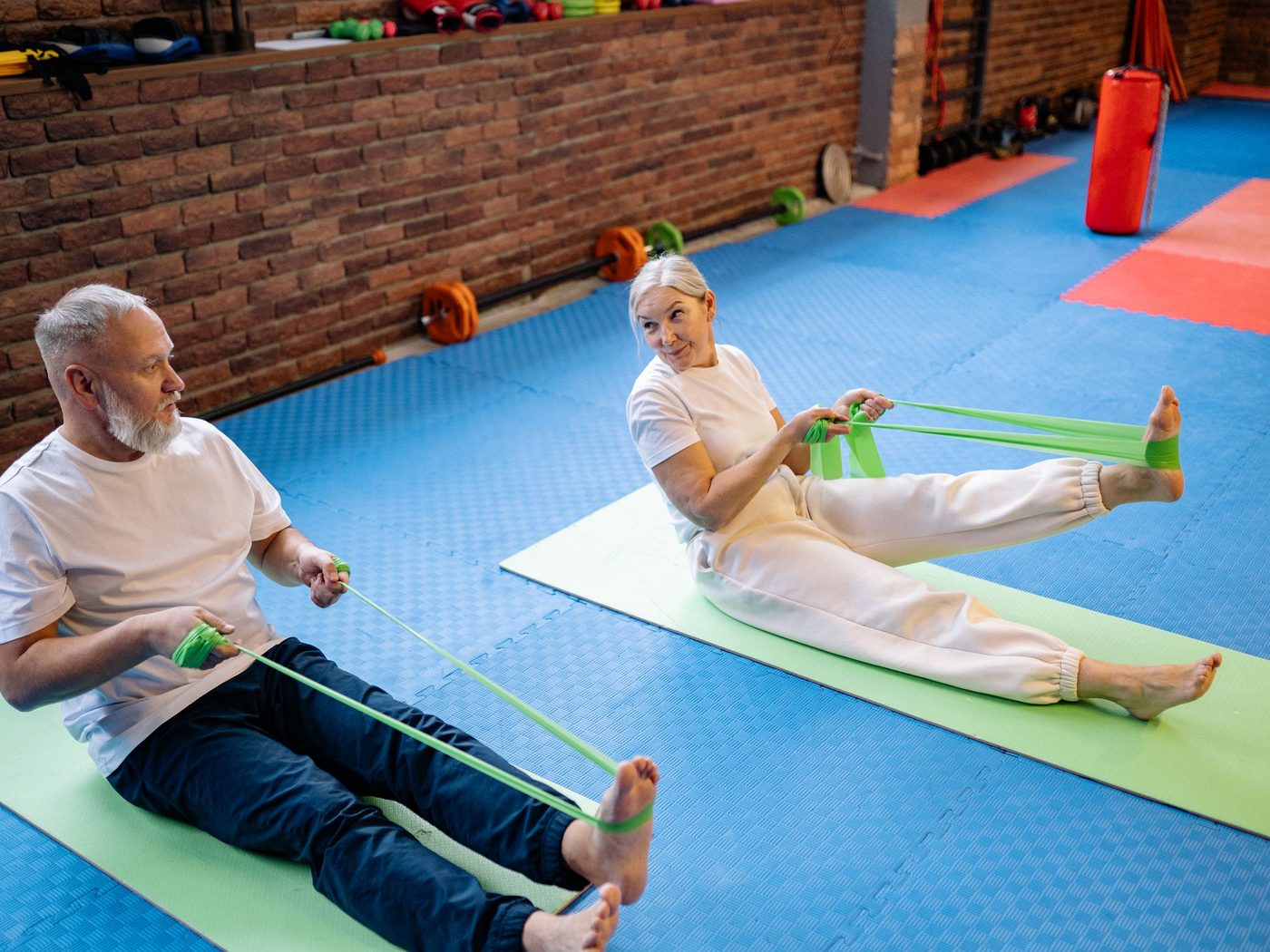 Two people exercising together with resistance bands